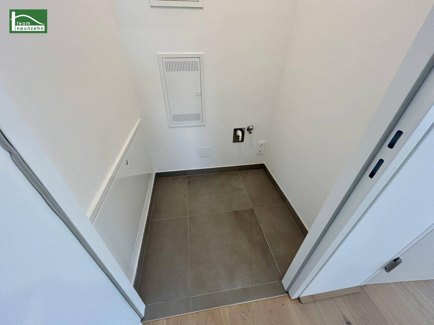 Praktischer Hauswirtschaftsraum mit Fliesenboden und Anschlüssen für Waschmaschine und Trockner.