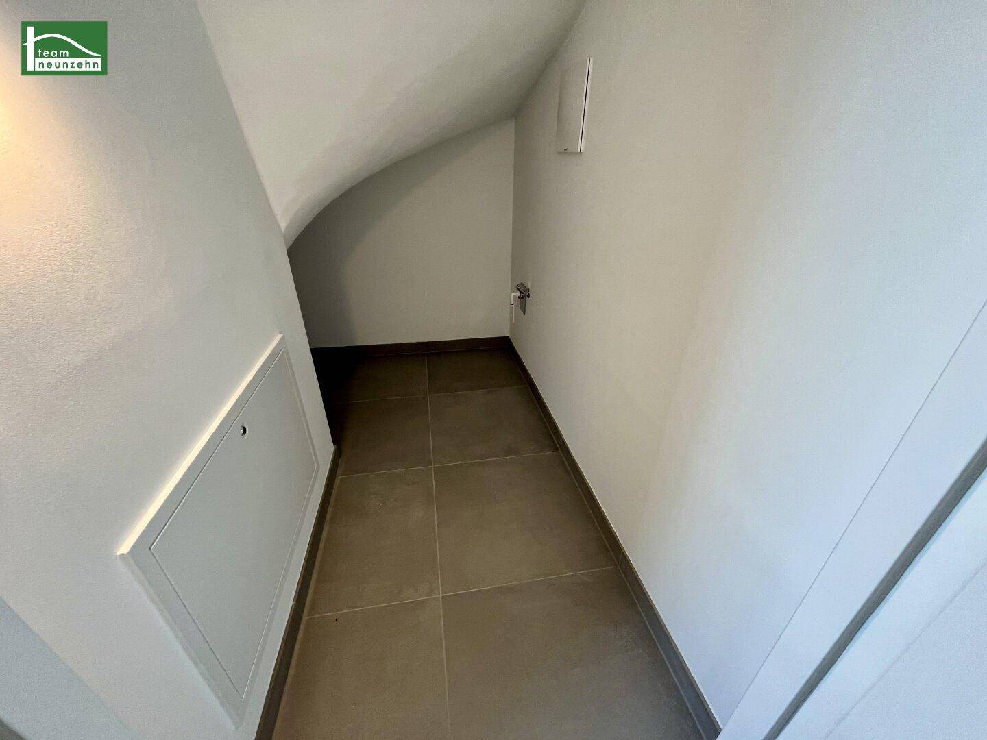 Praktischer Abstellraum unter der Treppe mit Fliesenboden, ideal für zusätzlichen Stauraum.