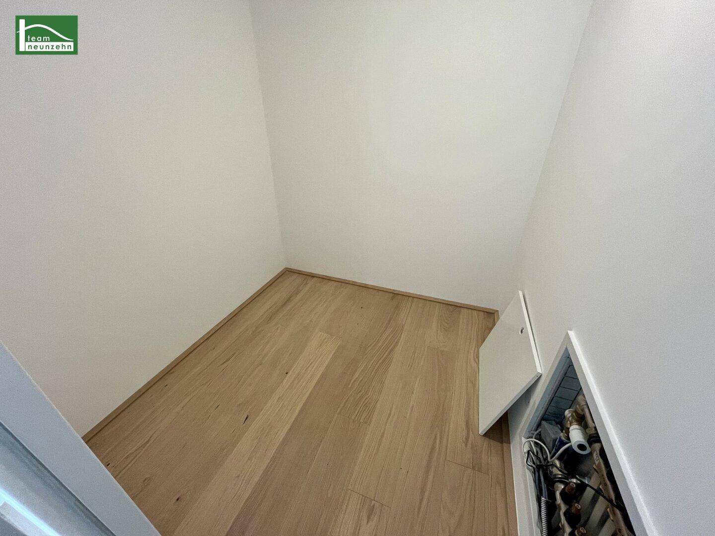 Praktischer Abstellraum mit Holzboden und Zugang zu Installationen unter der Dachschräge.