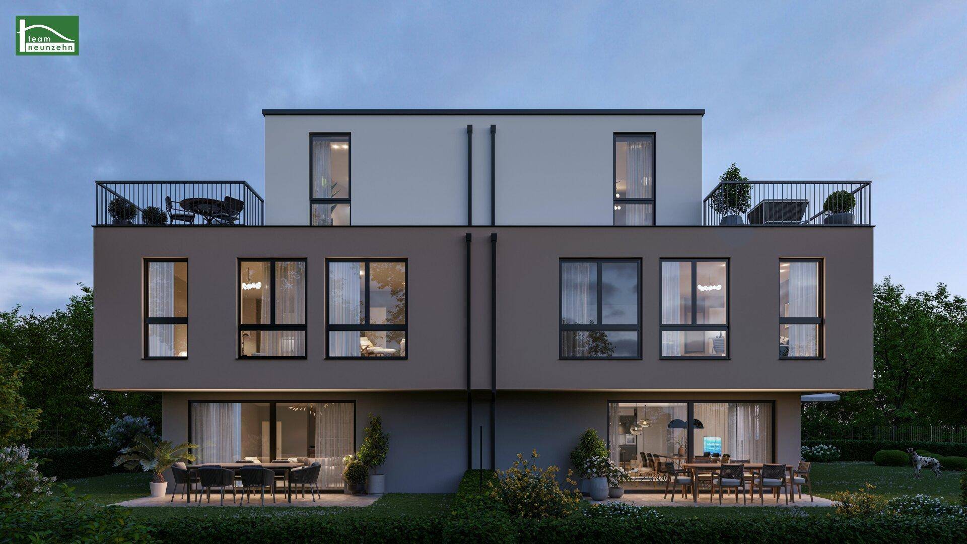 Rückansicht des modernen Doppelhauses bei Dämmerung mit Terrassen und Gärten.