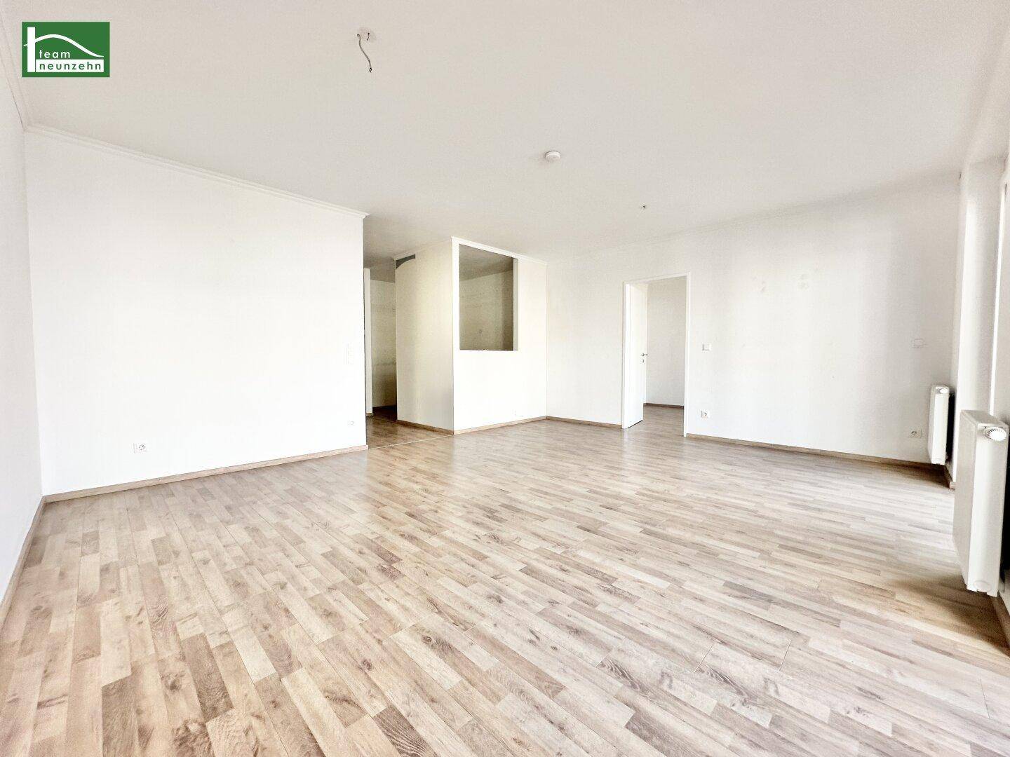 Geräumiges, unmöbliertes Zimmer mit Laminatboden und viel Tageslicht, ideal für Wohnzwecke.