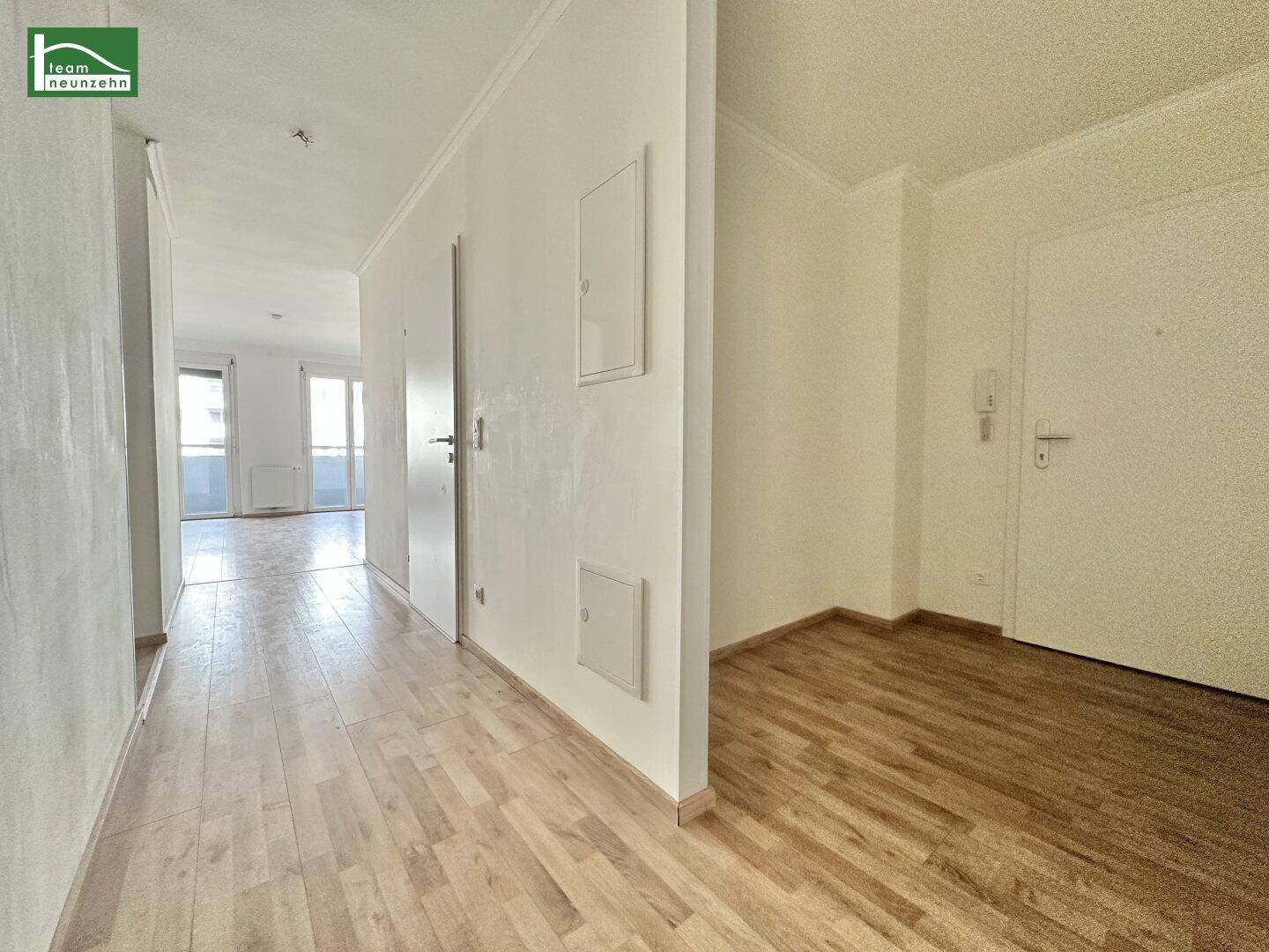 Heller Flur mit Laminatboden und Zugang zu weiteren Räumen, inklusive Blick auf Fenster.