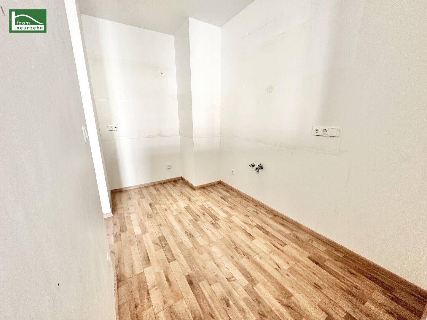 Kleiner, leerer Raum mit Laminatboden und Anschlüssen, ideal als Abstellraum oder kleine Küche.