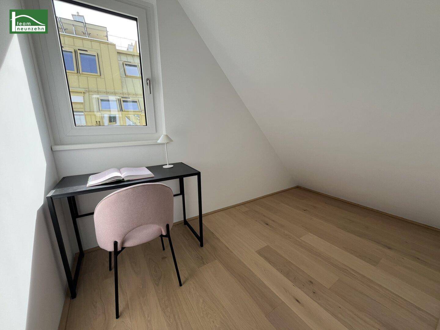 Kleines Arbeitszimmer mit Schreibtisch, Fenster und Dachschräge, ideal für Home-Office.