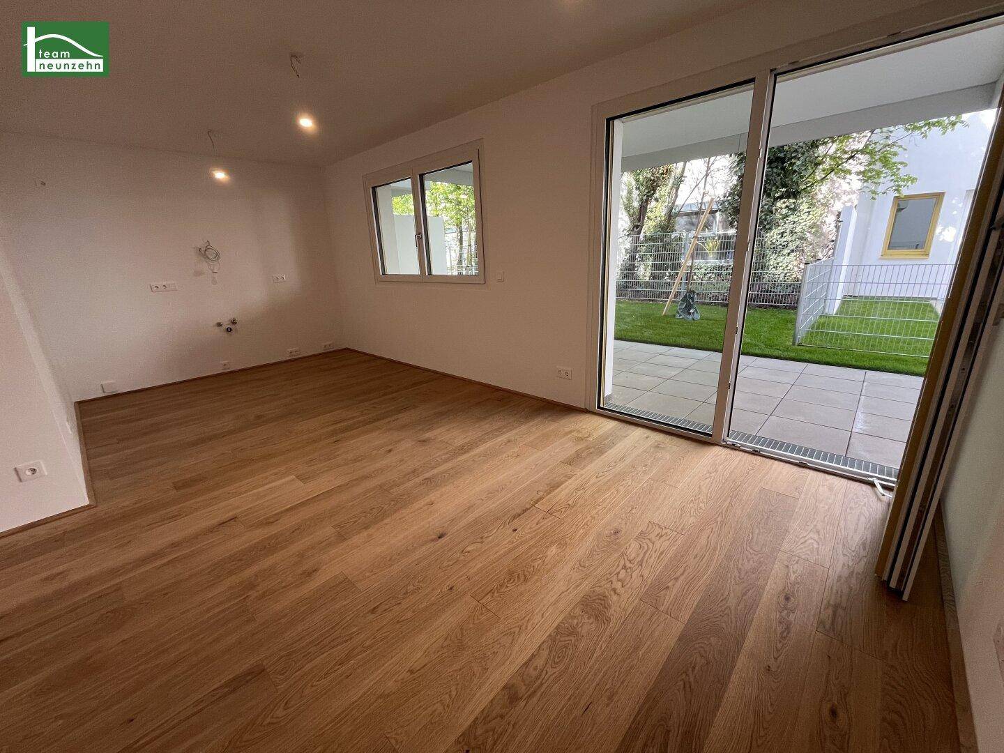 Lichtdurchfluteter Wohnbereich mit Holzboden und großer Schiebetür zum Außenbereich.