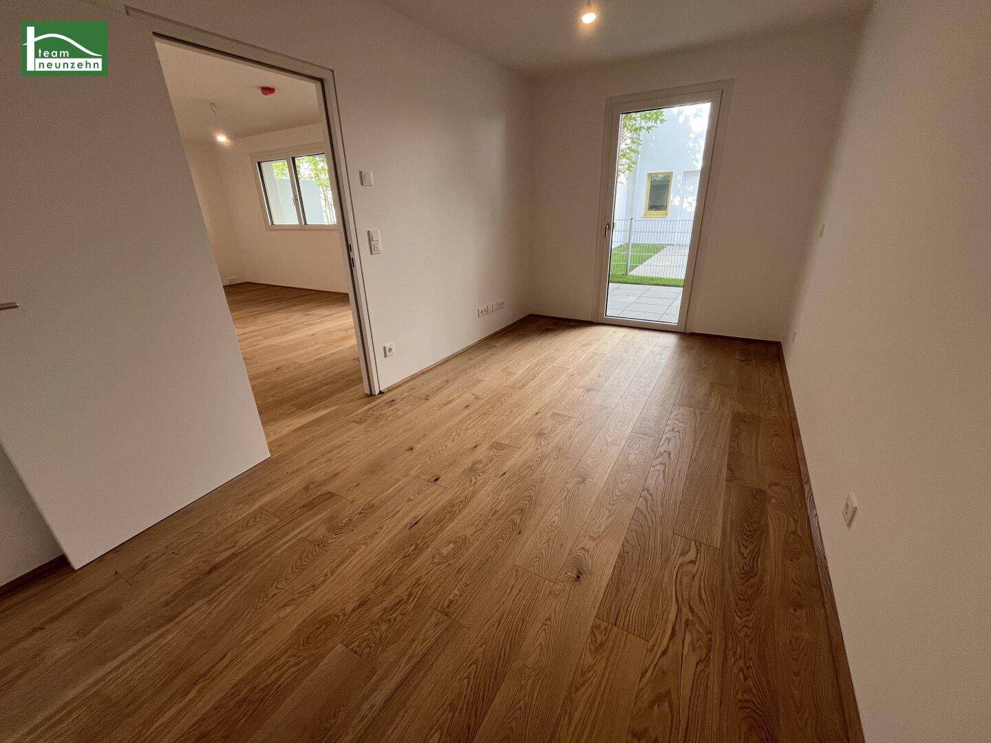 Unmöbliertes Zimmer mit hellem Holzboden und direktem Zugang zum Außenbereich.