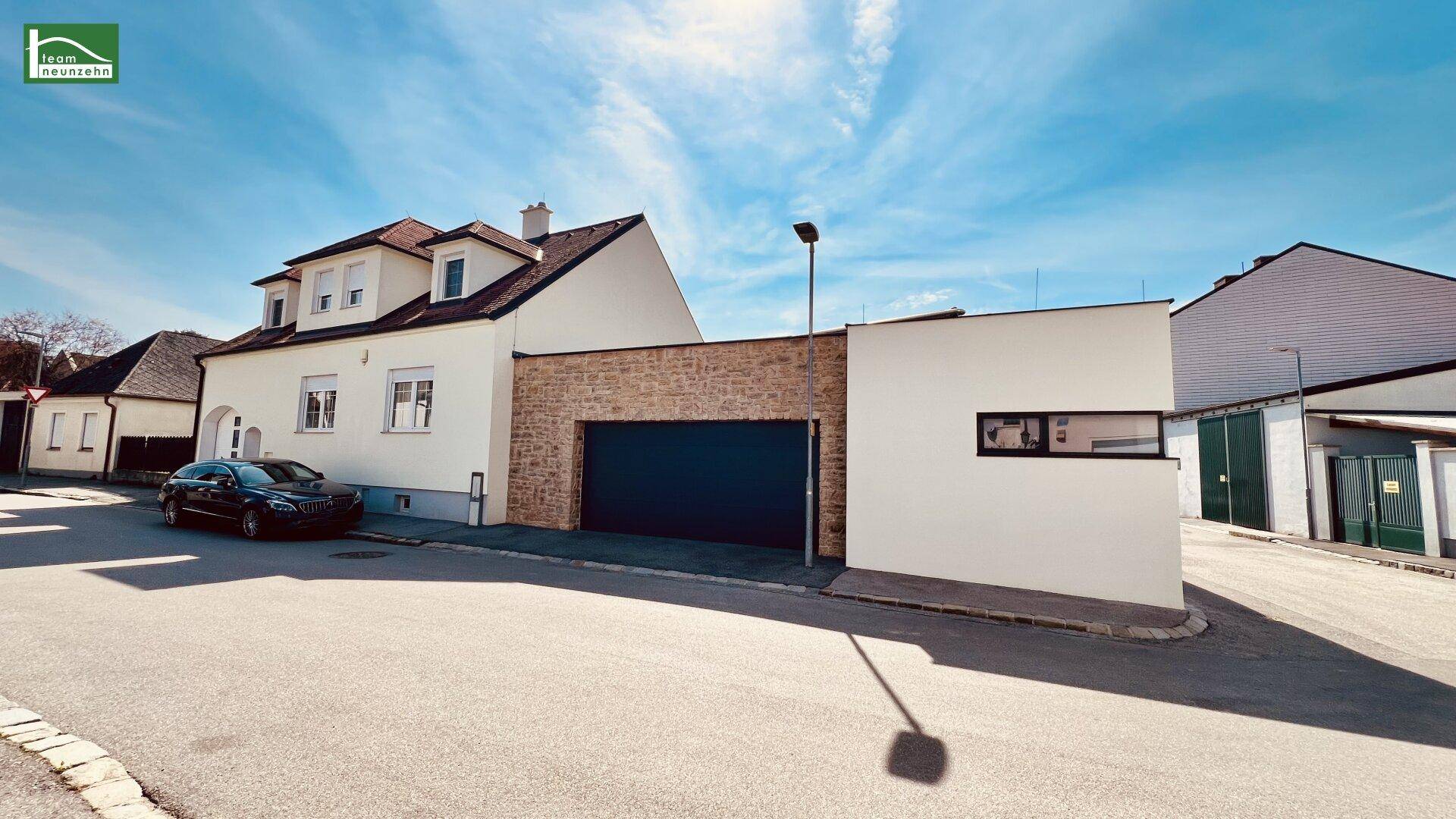 Ansicht des Hauses von der Straße mit moderner Architektur und Garage.