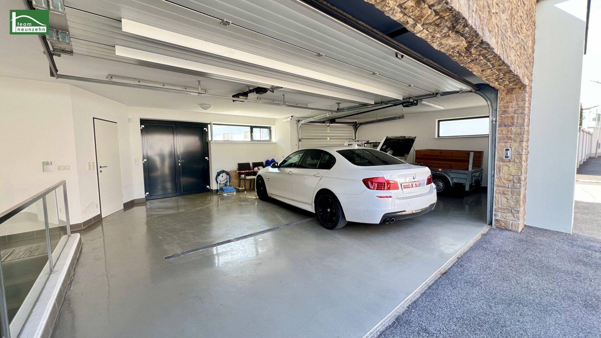 Moderne Garage mit Fliesenboden und ausreichend Platz für ein Fahrzeug.