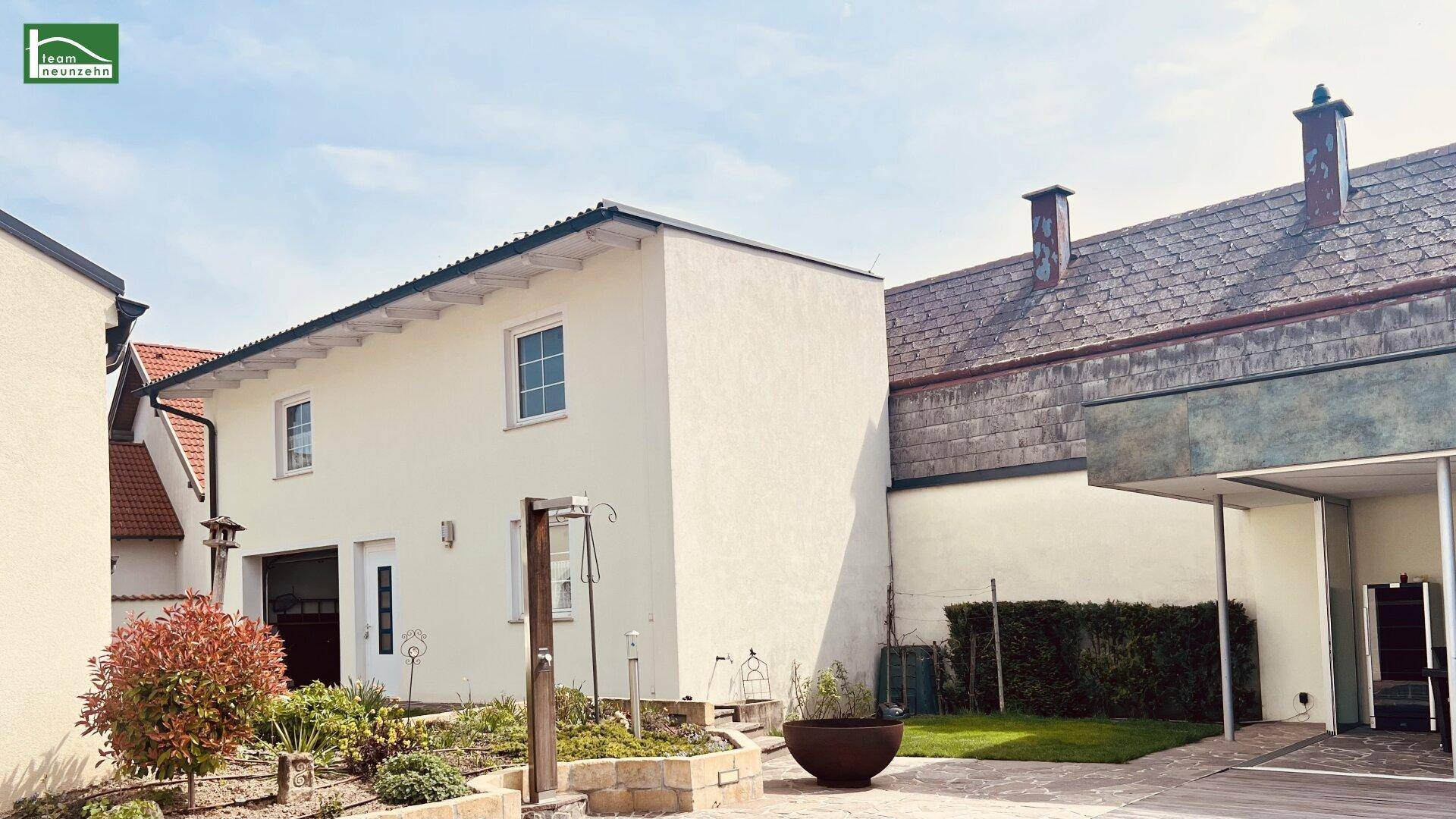 Außenansicht des Hauses mit gepflegtem Garten, Rasenfläche und gepflastertem Weg.