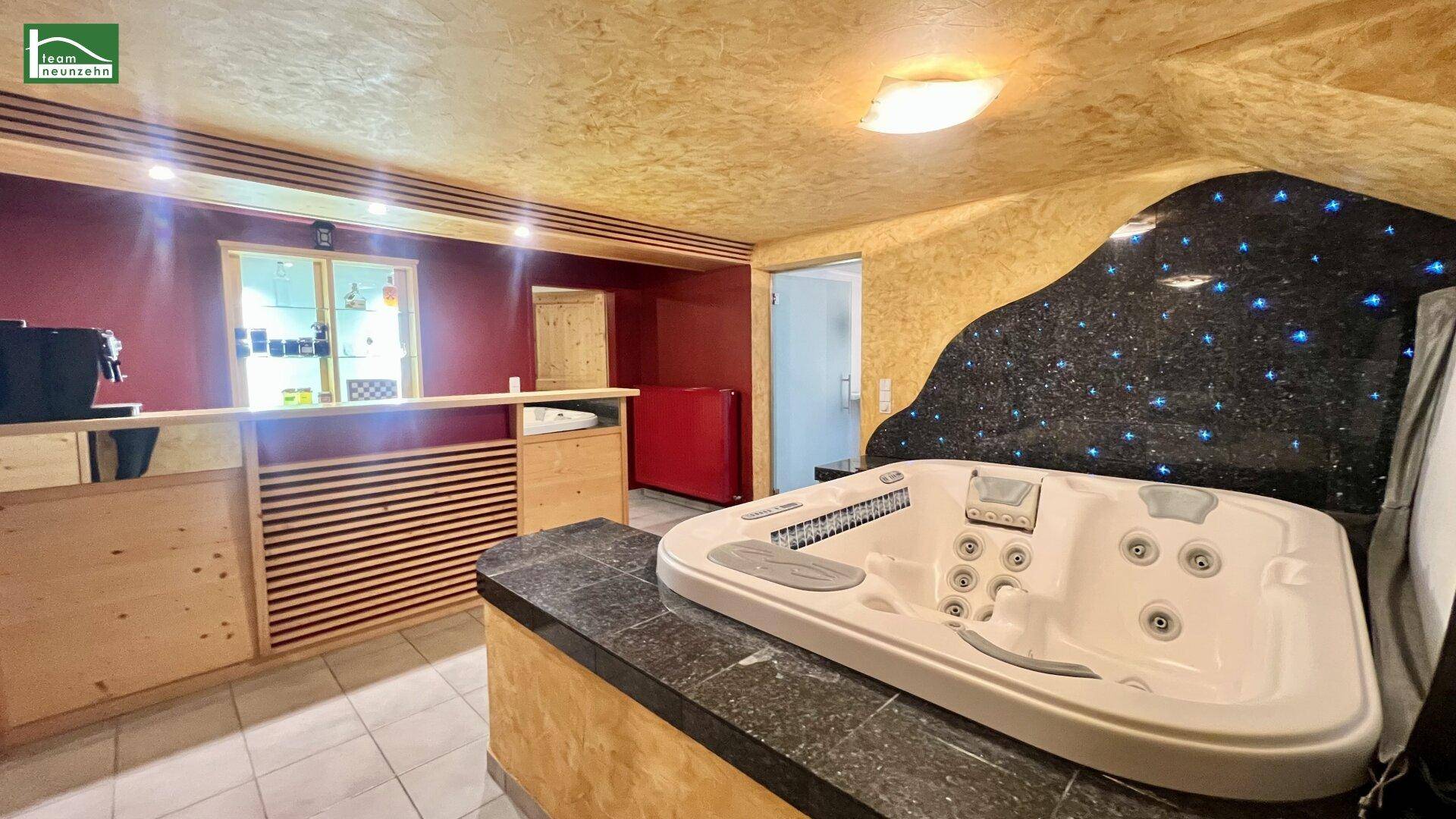 Wellnessbereich mit Whirlpool, Barbereich und gemütlicher Atmosphäre.