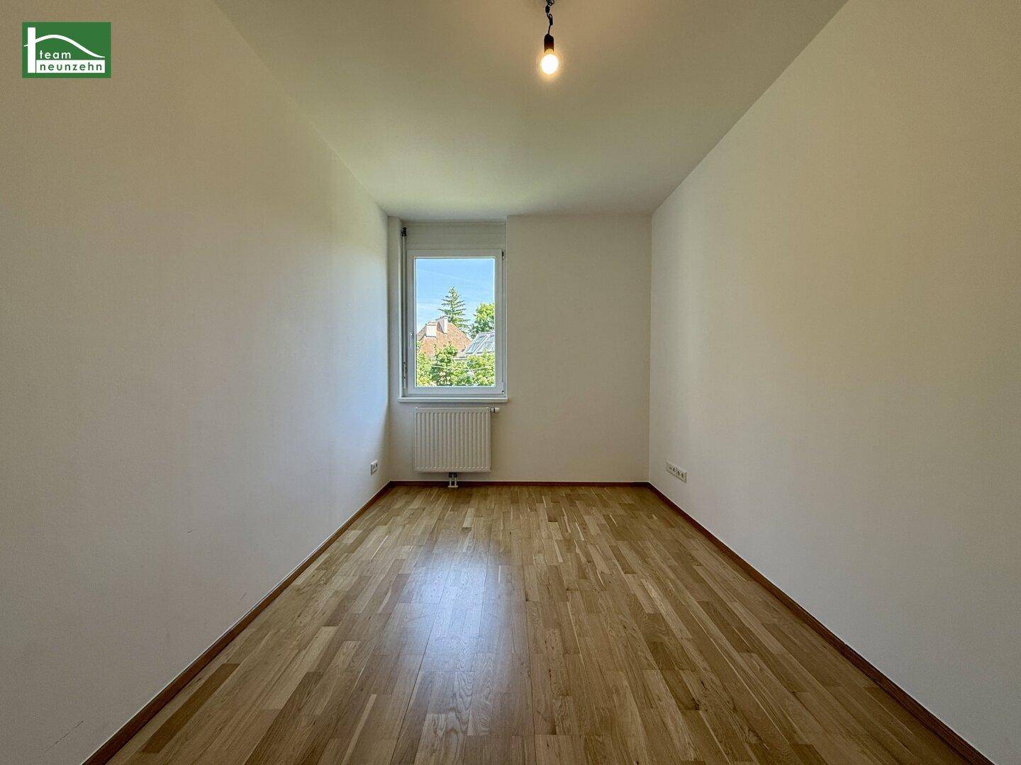 Ruhiges Zimmer mit Holzboden und einem Fenster, das für natürliche Belichtung sorgt.