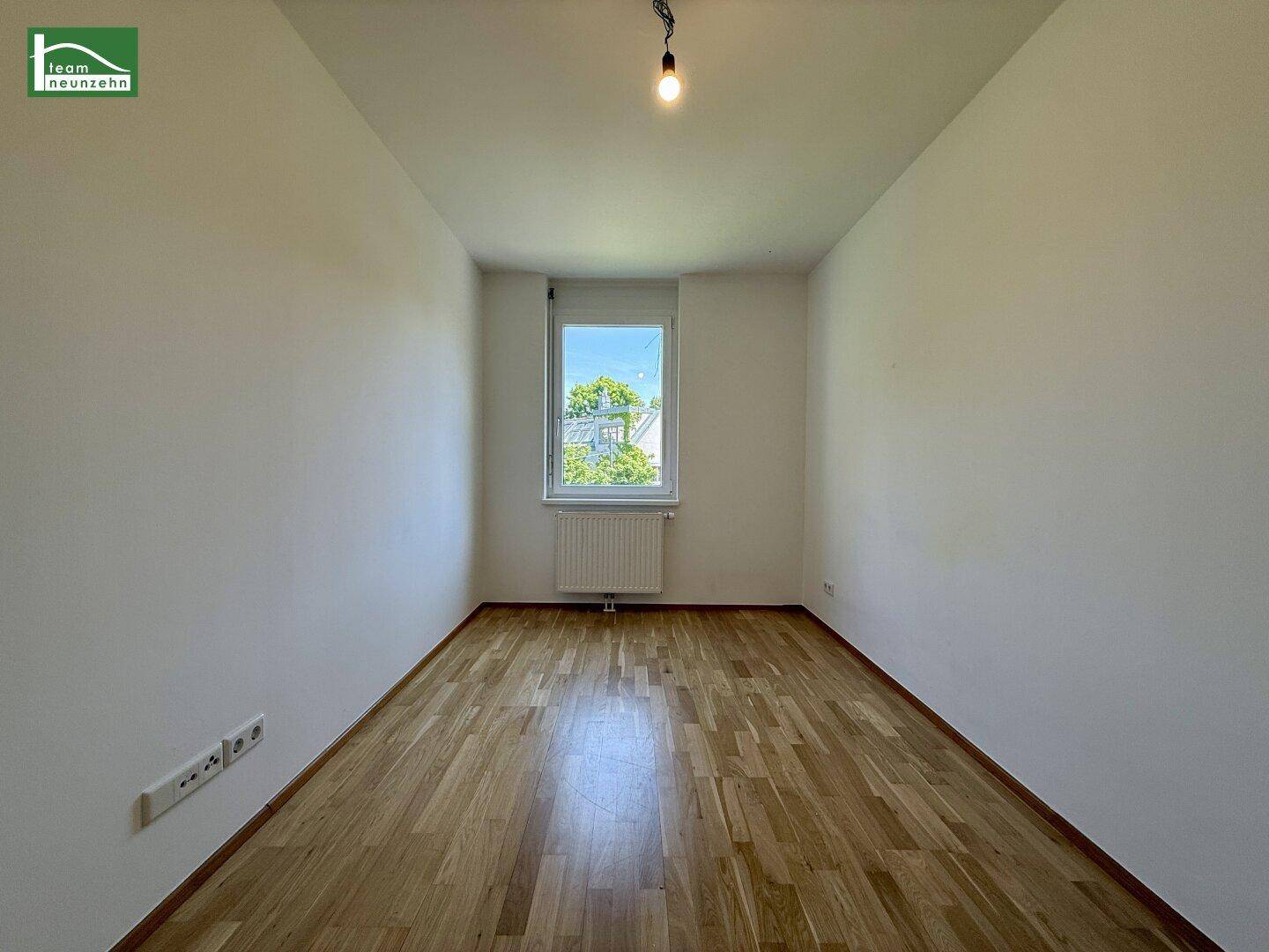 Weiteres helles Zimmer mit Holzboden und einem Fenster, ideal als Schlaf- oder Arbeitszimmer.