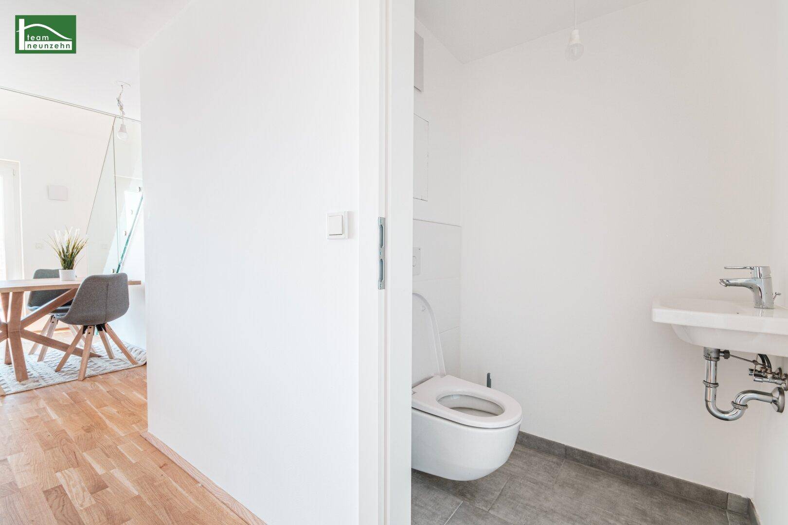 Modernes Gäste-WC mit wandhängender Toilette und kleinem Waschbecken.
