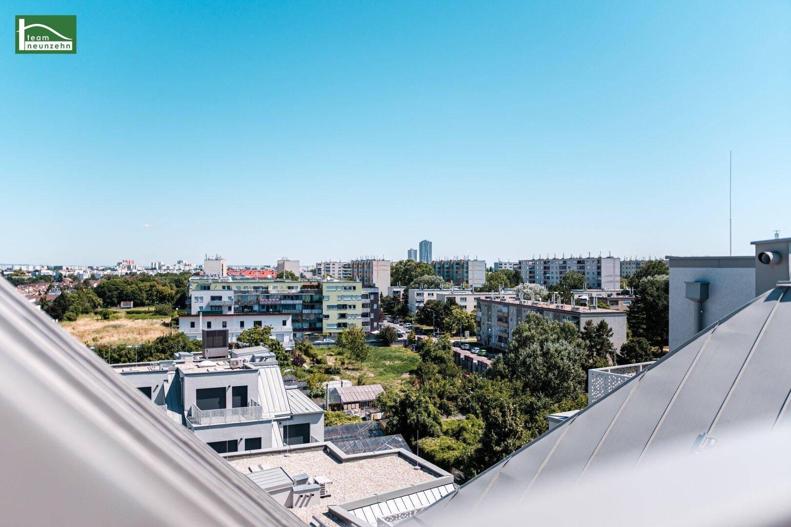 Panoramablick über die Dächer der Stadt mit weitem Horizont und grünen Inseln.