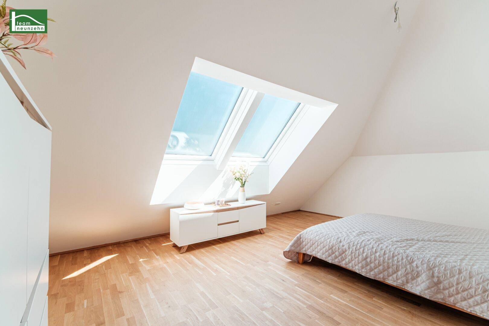 Lichtdurchflutetes Schlafzimmer mit großen Dachfenstern und hellem Holzboden im modernen Stil.