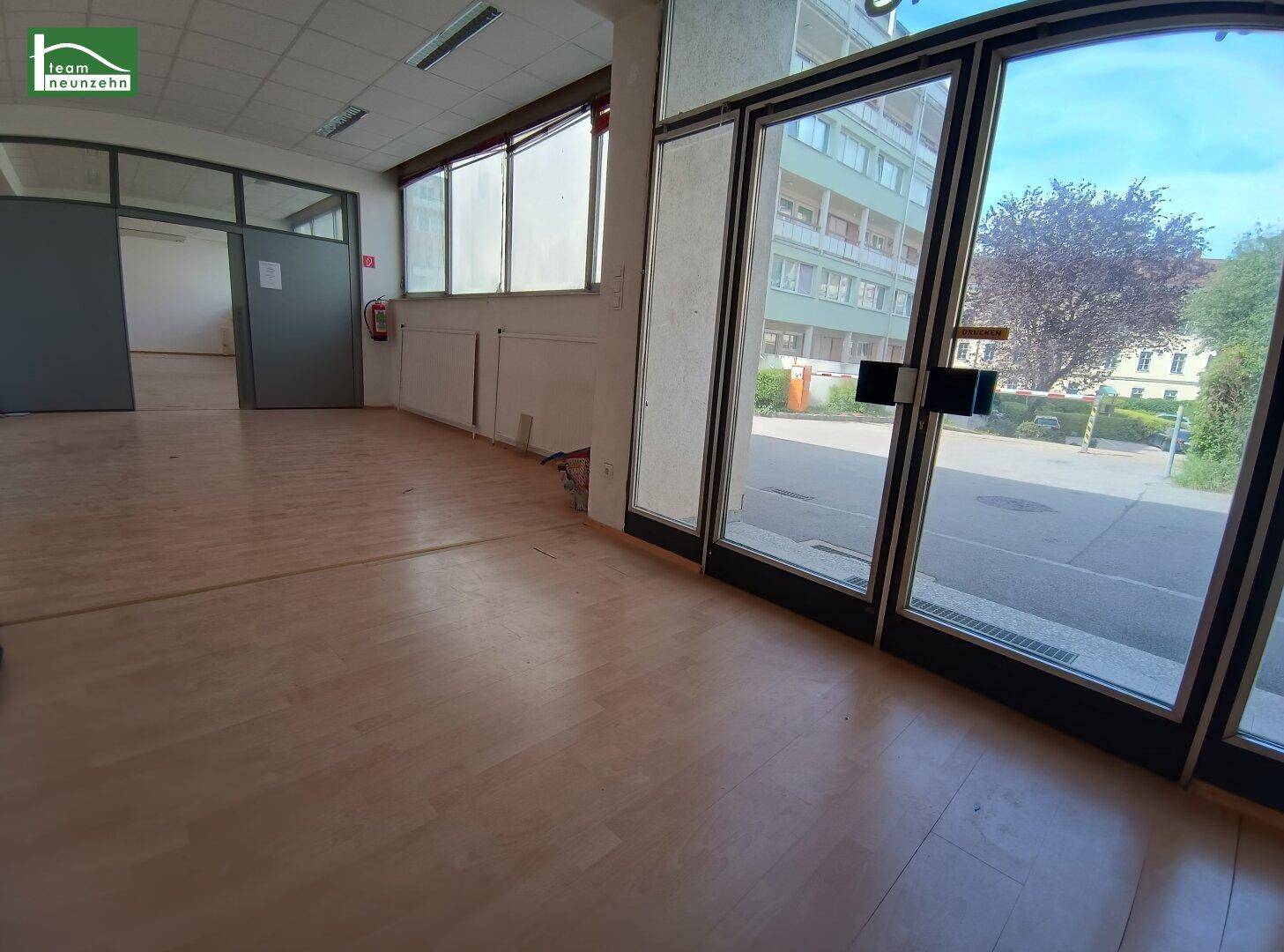 Heller Ladenraum mit großen Glasfronten und direktem Zugang zur Straße.