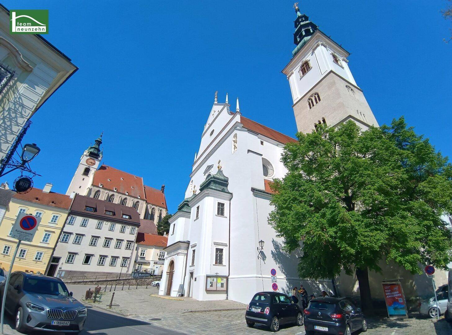 Ansicht einer großen Kirche und weiterer historischer Gebäude in einer malerischen Stadt.