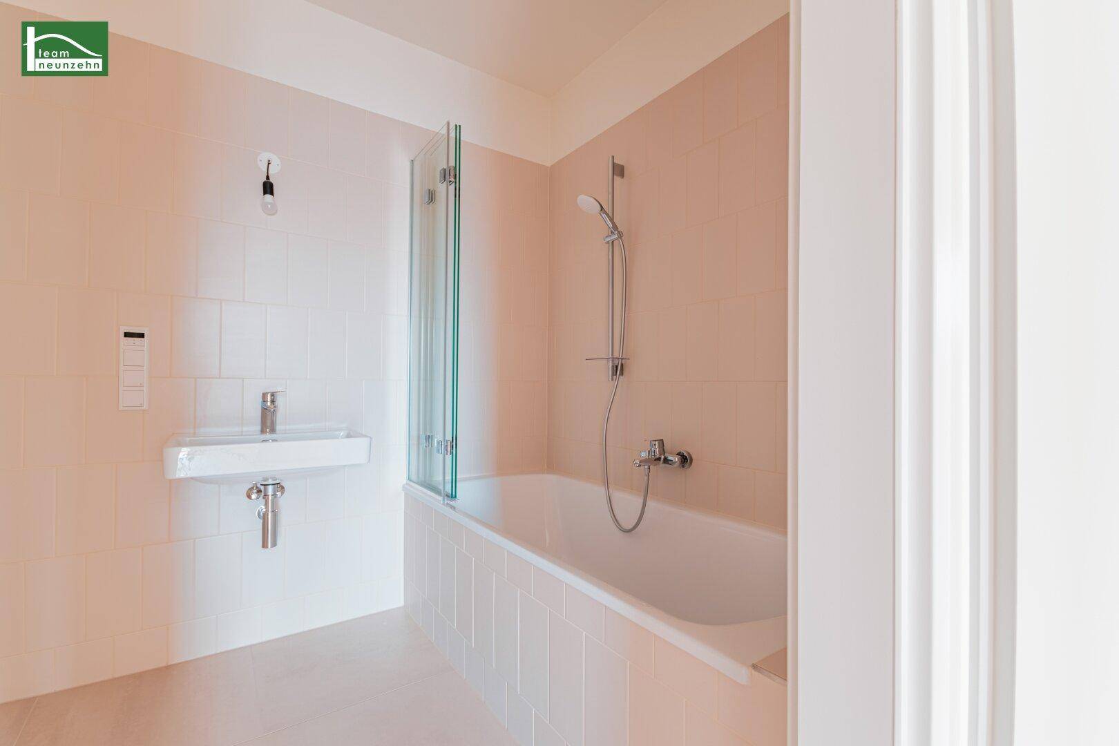 Modernes Badezimmer mit Badewanne, Duschabtrennung und hellem Waschtisch.