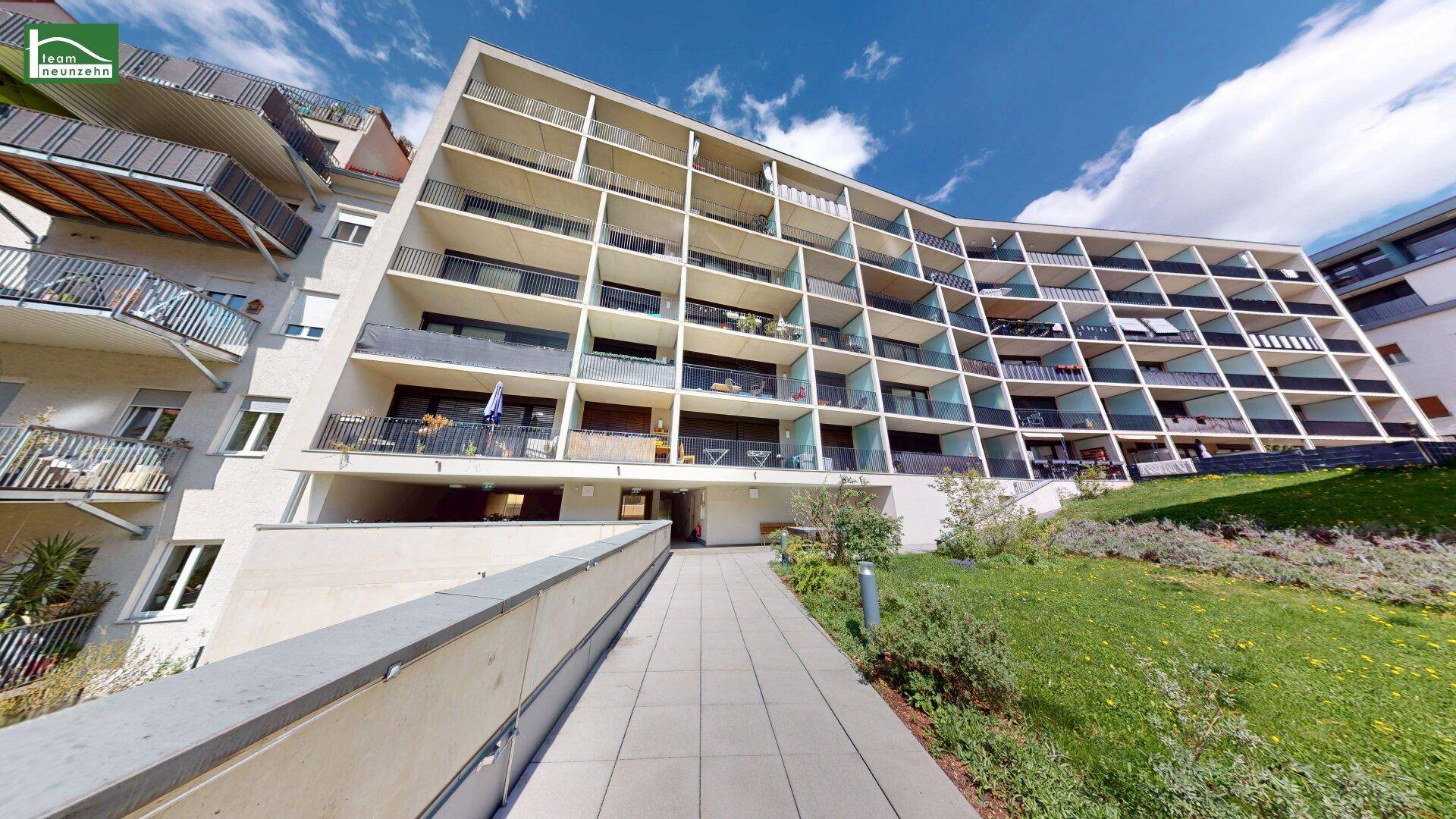 Ansicht einer modernen Wohnanlage mit markanter Architektur und gepflegten Außenanlagen.