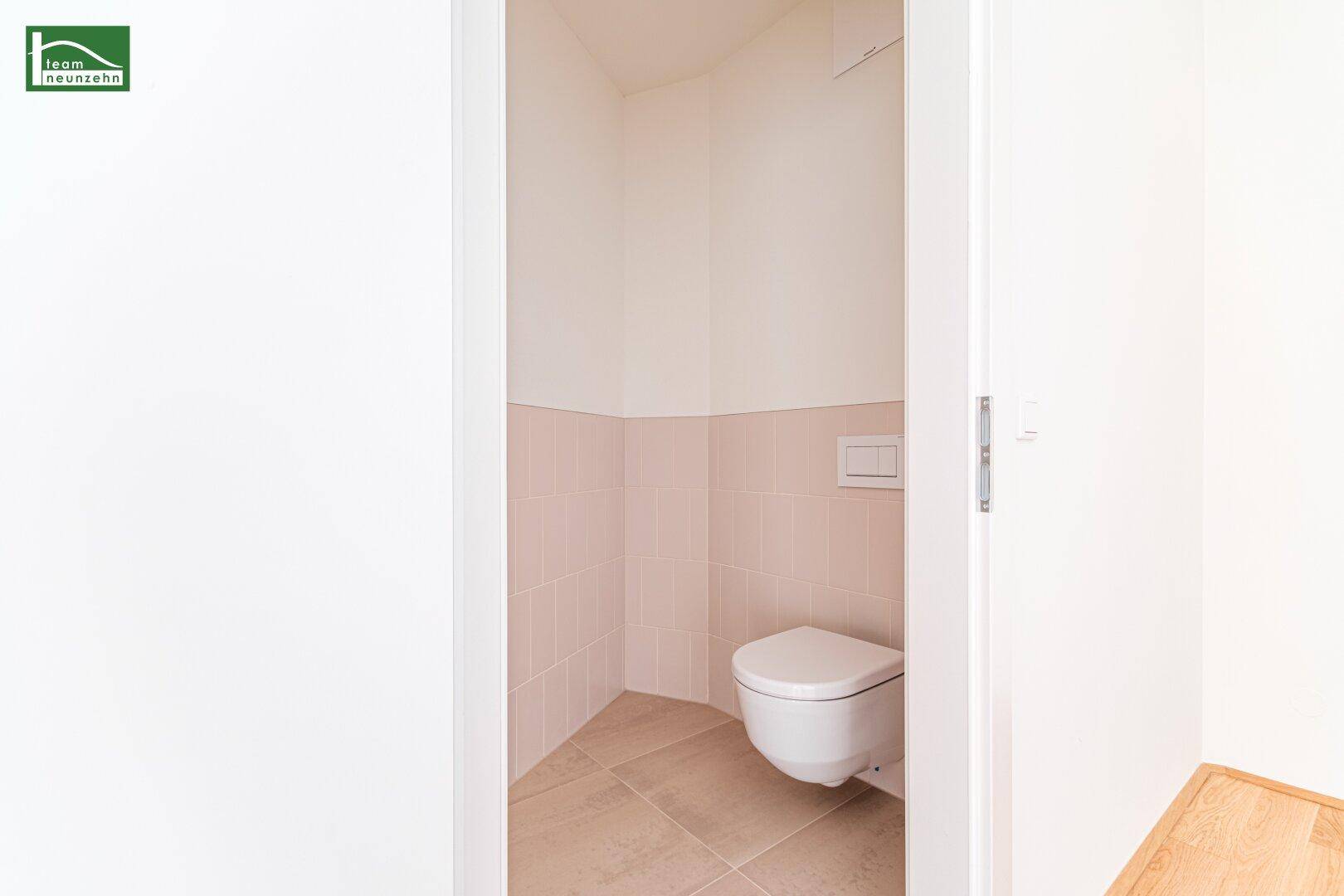 Separates WC mit wandhängender Toilette und hellen Fliesen, praktisch und platzsparend.