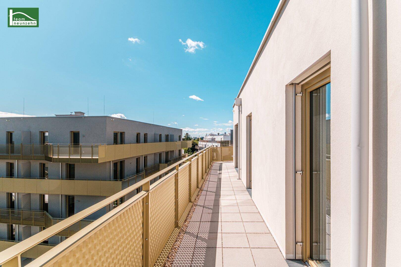 Langer Balkon mit Fliesenboden und Metallgeländer, bietet einen weiten Blick.