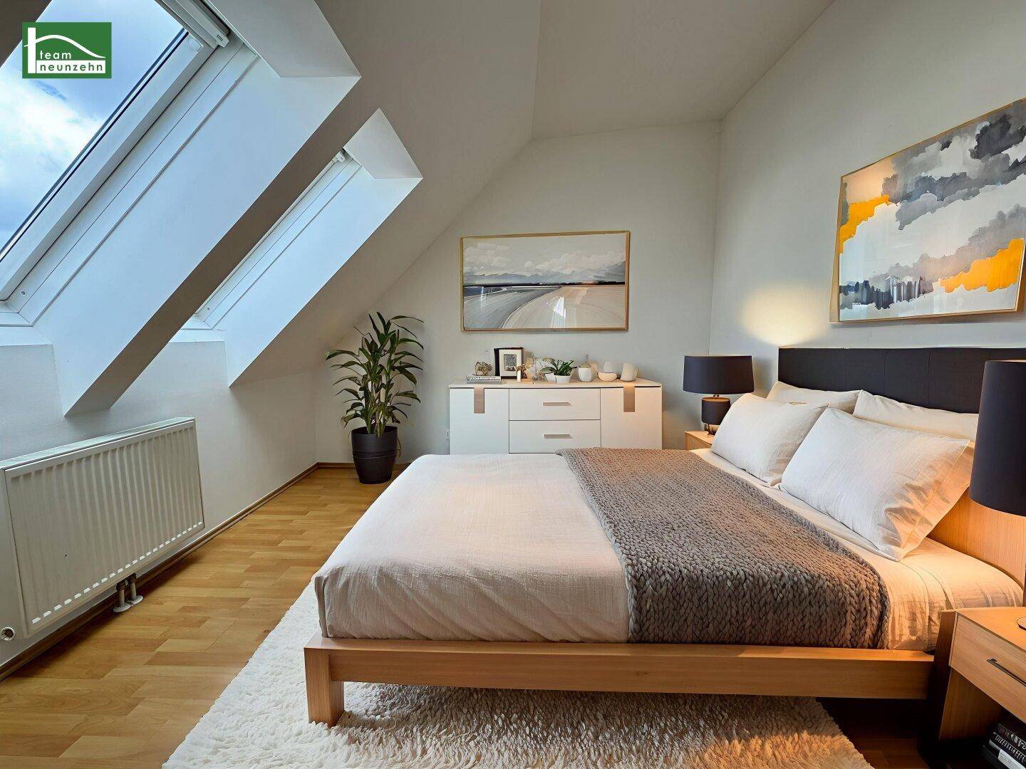 Helles Schlafzimmer mit Holzboden, Dachschrägen und großen Dachfenstern für viel Tageslicht.