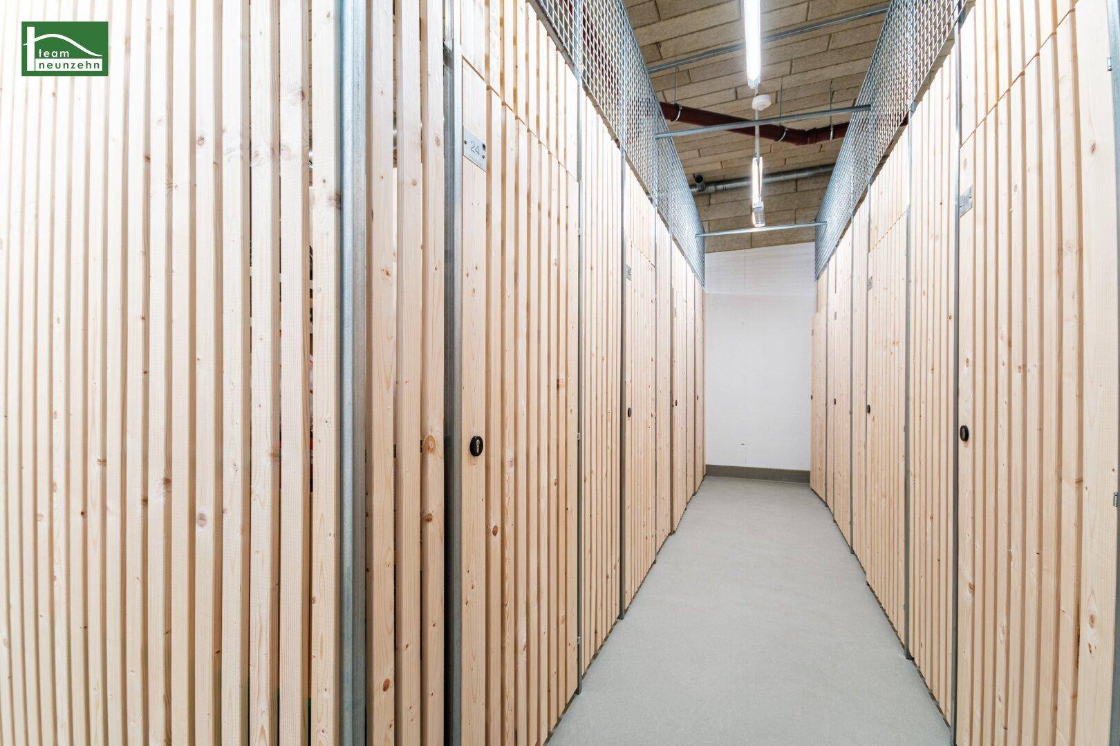 Reihe von Kellerabteilen mit Holzabtrennungen, die zusätzlichen Stauraum bieten.