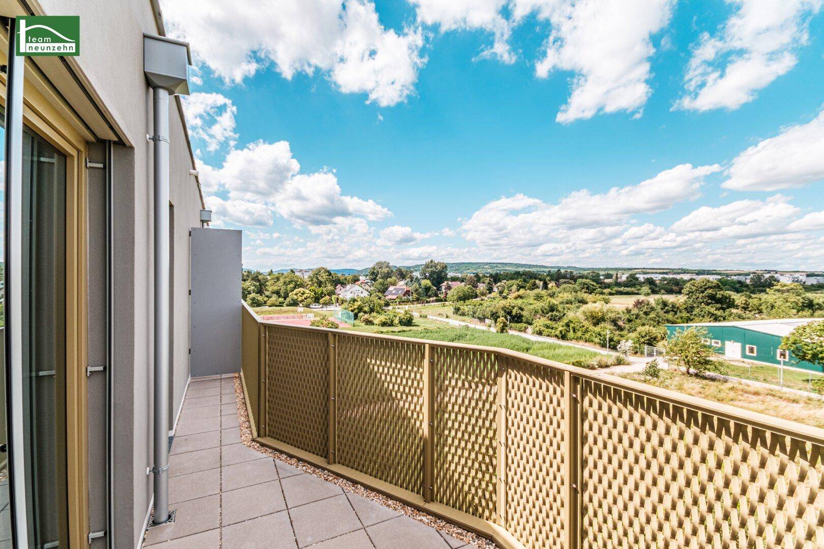 Langer Balkon mit Gittergeländer und Panoramablick über die Landschaft.