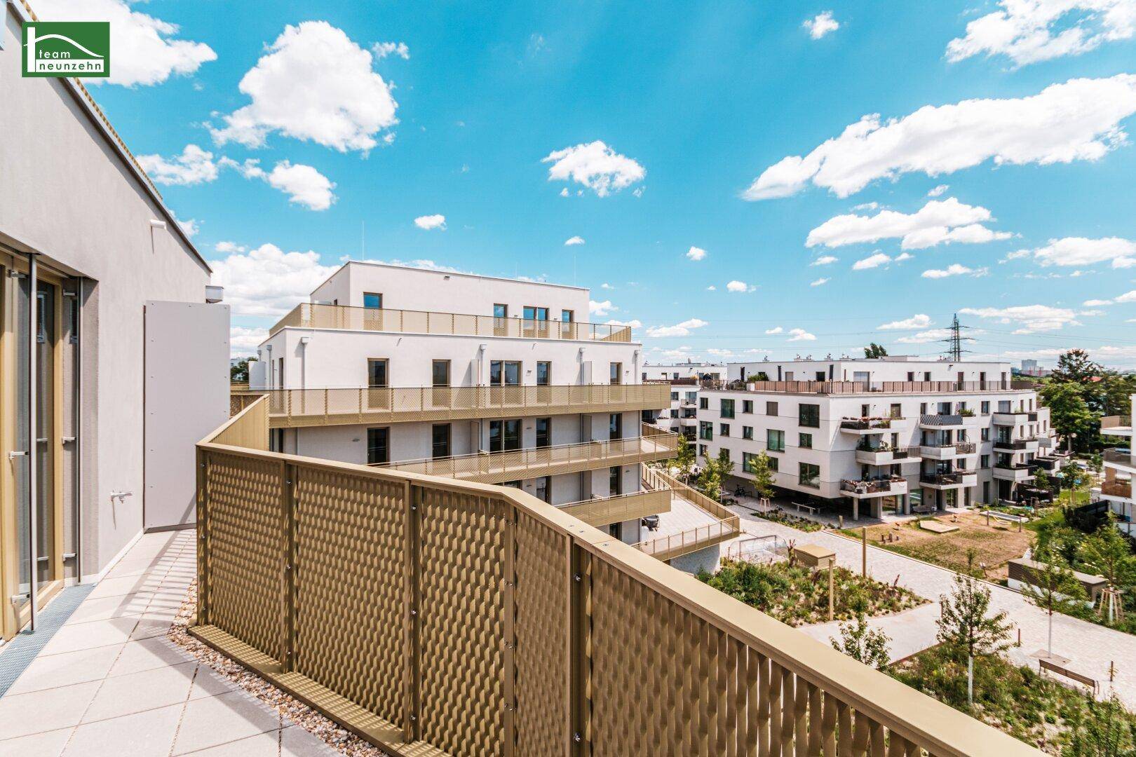 Geräumiger Balkon mit moderner Metallbrüstung und Blick auf die umliegenden Neubauten.
