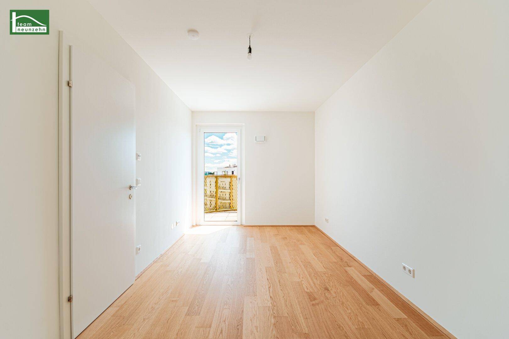 Lichtdurchflutetes Schlafzimmer mit hellem Holzboden und direktem Zugang zum Außenbereich.