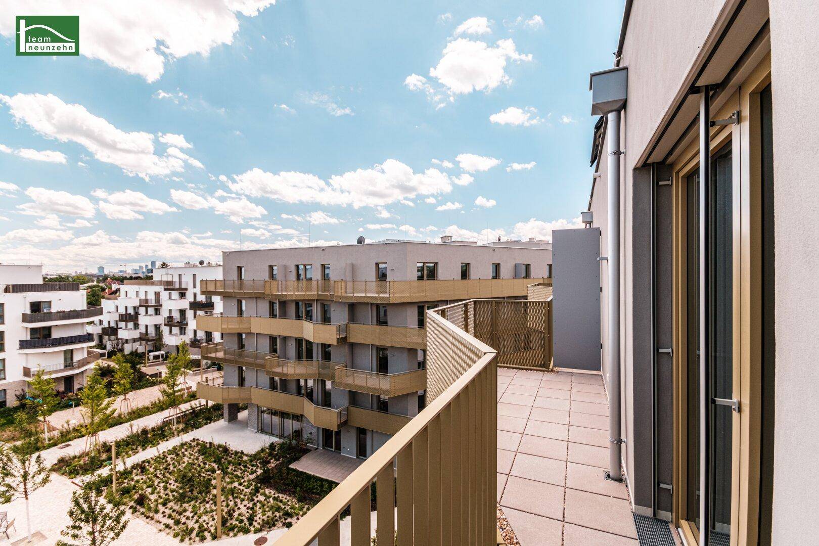Große Dachterrasse mit Fliesenboden und Blick auf die umliegenden Wohngebäude und die Stadt.