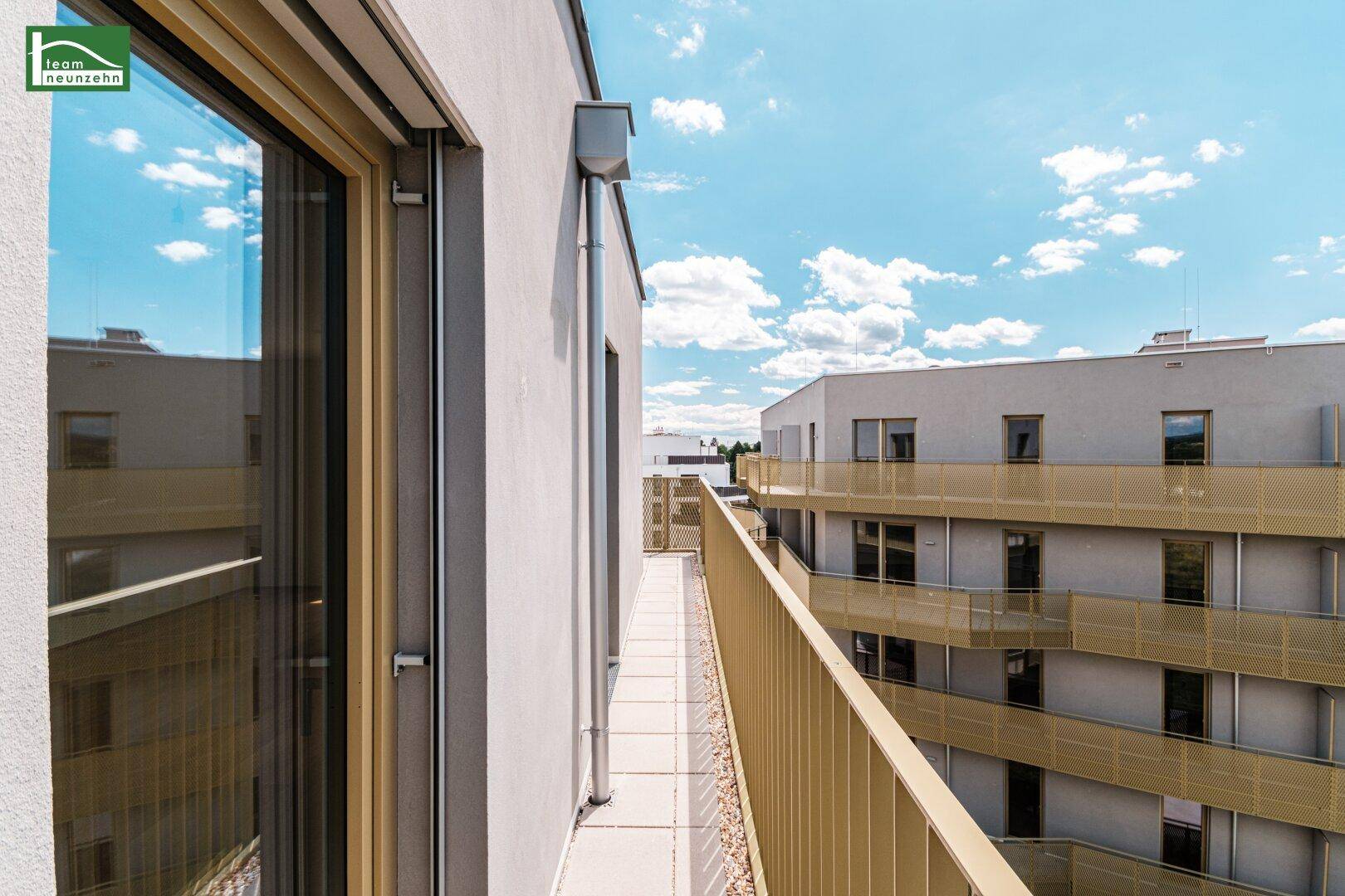 Schmaler Balkon mit moderner Brüstung und Blick auf die benachbarten Gebäude.