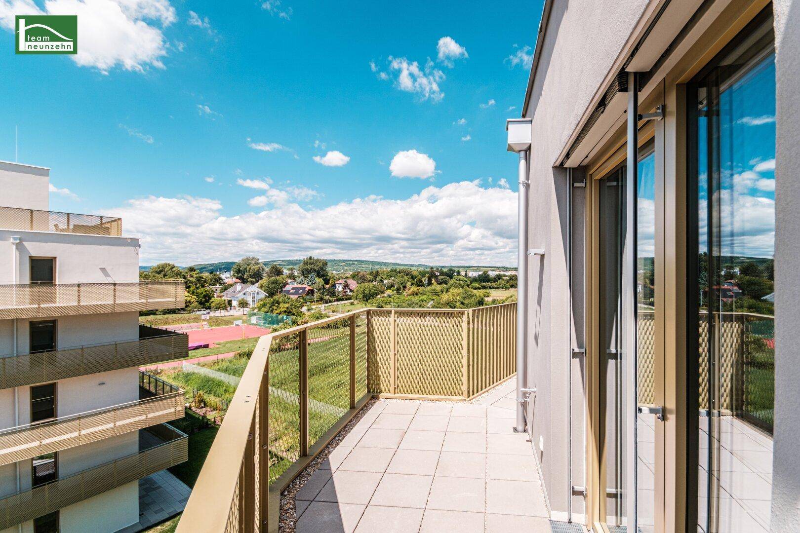 Langer Balkon mit weitem Blick über die grüne Umgebung und die Dächer der Stadt.