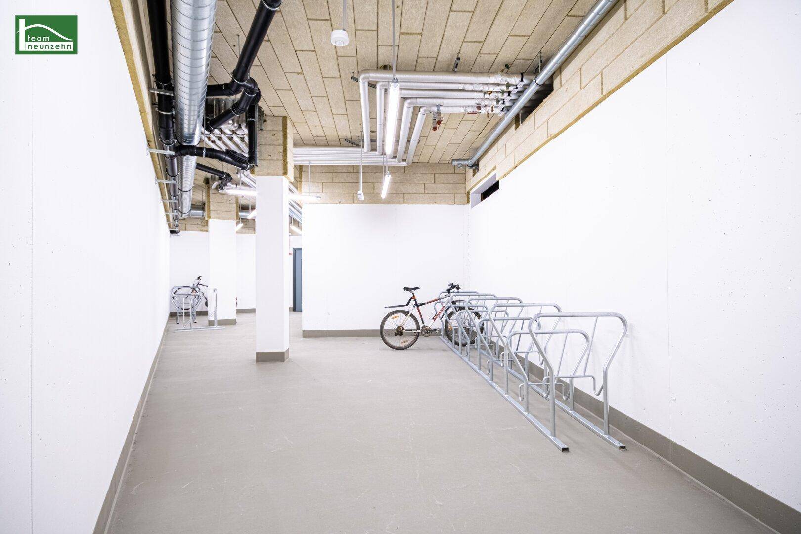 Geräumiger Fahrradraum im Untergeschoss mit praktischen Fahrradständern und guter Beleuchtung.