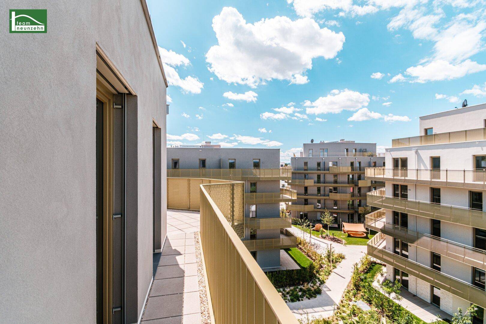Geräumiger Balkon mit Blick auf den Innenhof und die umliegenden modernen Wohngebäude.