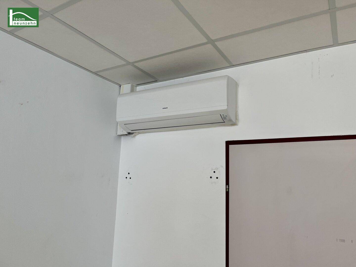 Nahaufnahme einer modernen Klimaanlage, die an einer weißen Wand montiert ist.
