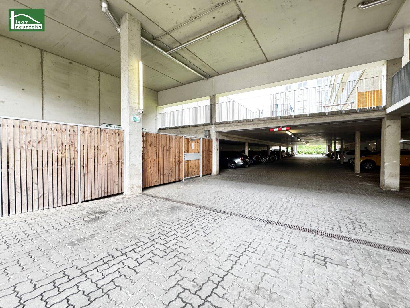 Tiefgarage mit ausreichend Stellplätzen und privaten Abstellbereichen aus Holz.
