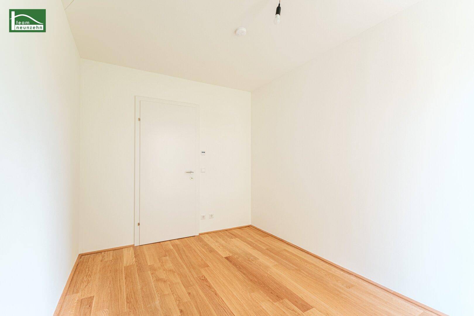 Unmöbliertes Zimmer mit hellem Parkettboden und weiß gestrichenen Wänden, ideal für Schlaf- oder Arbeitszimmer.