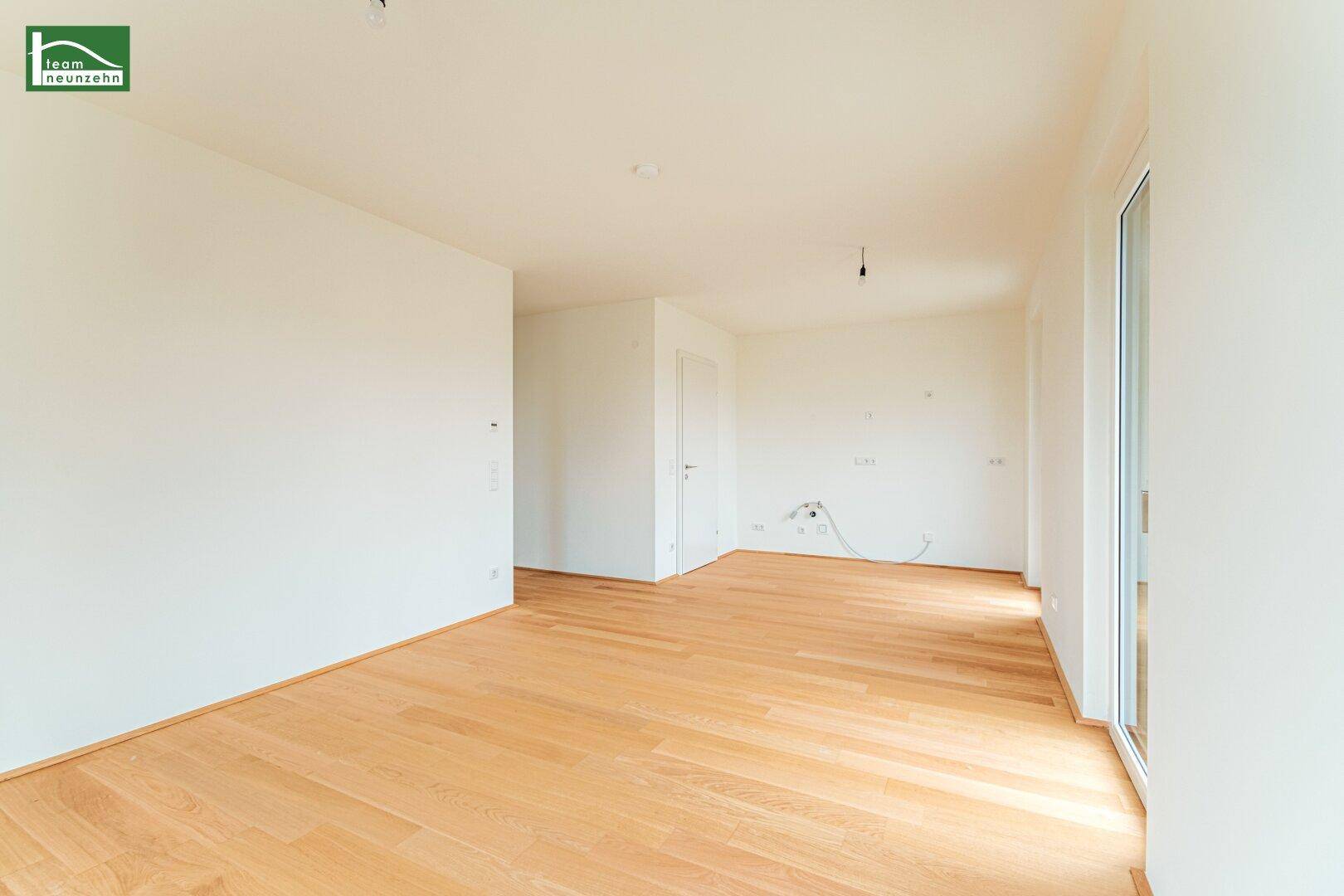 Geräumiger, heller Raum mit Parkettboden und großen Fenstern, ideal für Wohn- oder Essbereich.