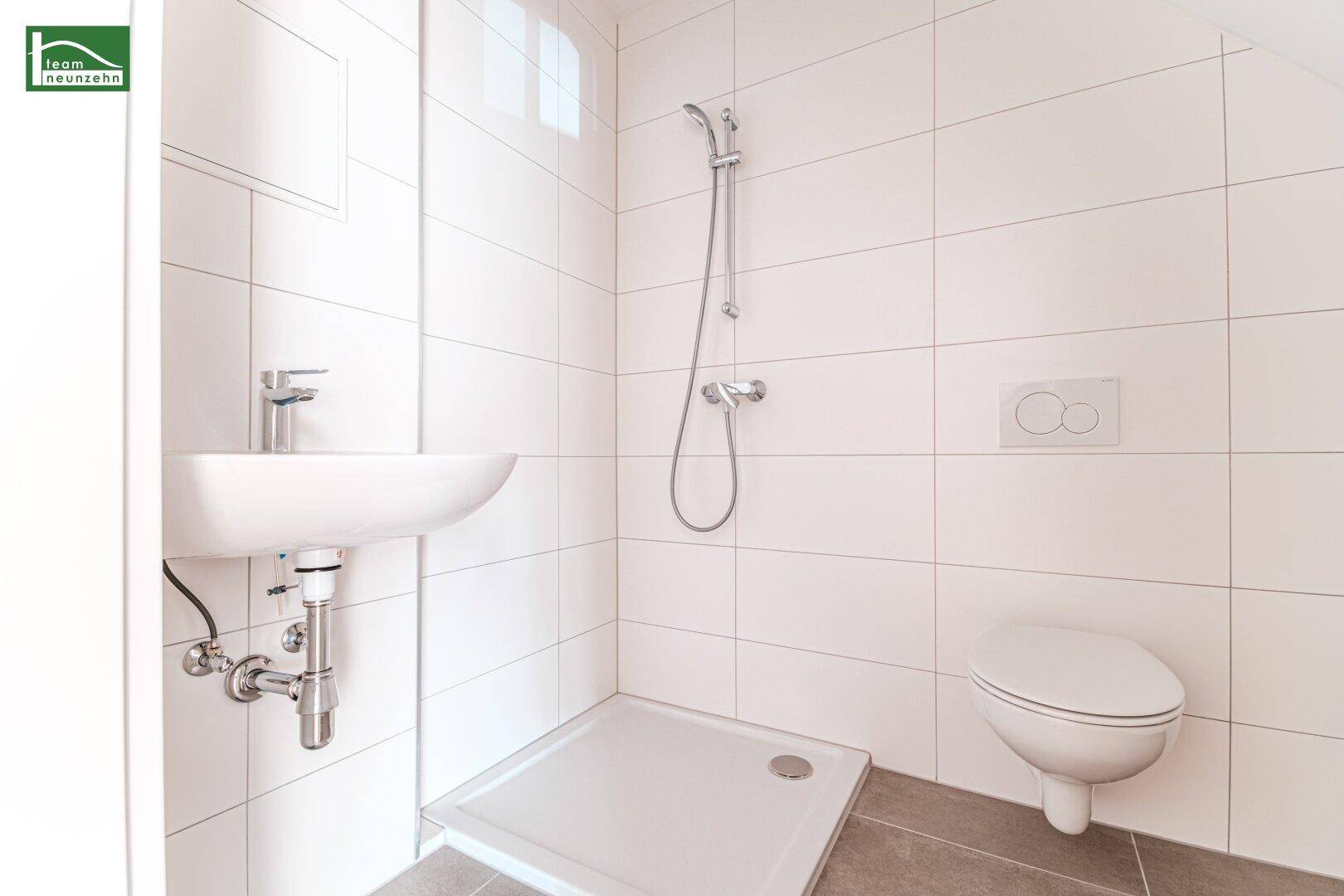 Modernes Badezimmer mit Dusche, Waschbecken und wandhängendem WC.
