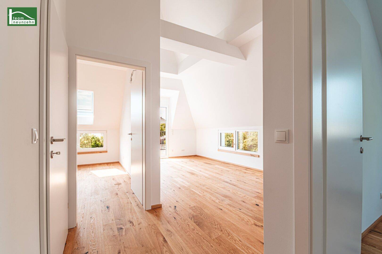 Heller Flur im Dachgeschoss mit Holzboden und Blick in angrenzende Räume.