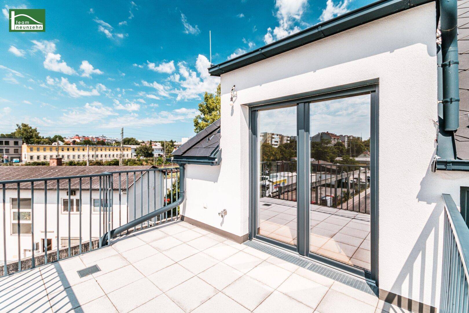 Große Dachterrasse mit Fliesenboden und weitem Blick über die Umgebung.