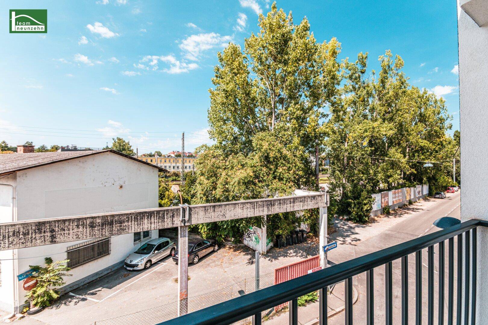 Balkon mit Blick auf Bäume und die städtische Umgebung, ideal für entspannte Stunden im Freien.