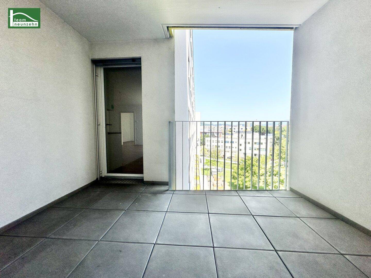 Geräumiger Balkon mit Fliesenboden und weitem Blick über die Stadt.