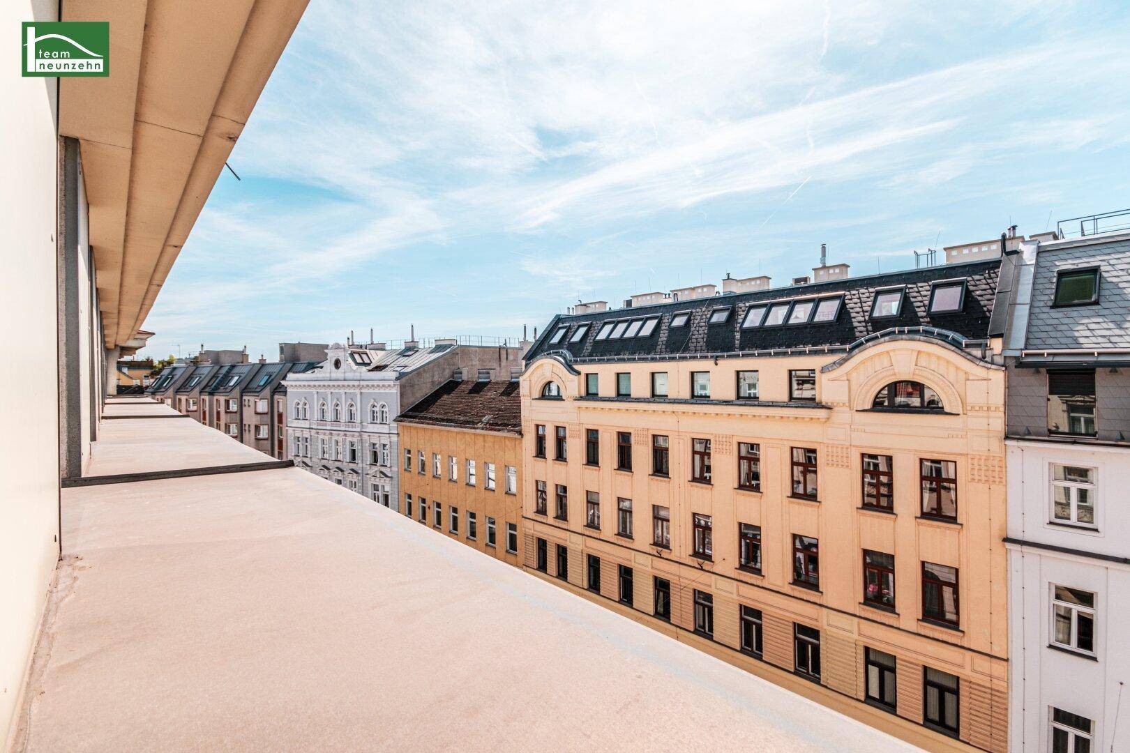 Panoramablick von einem Balkon auf eine lange Reihe historischer Gebäude entlang der Straße.