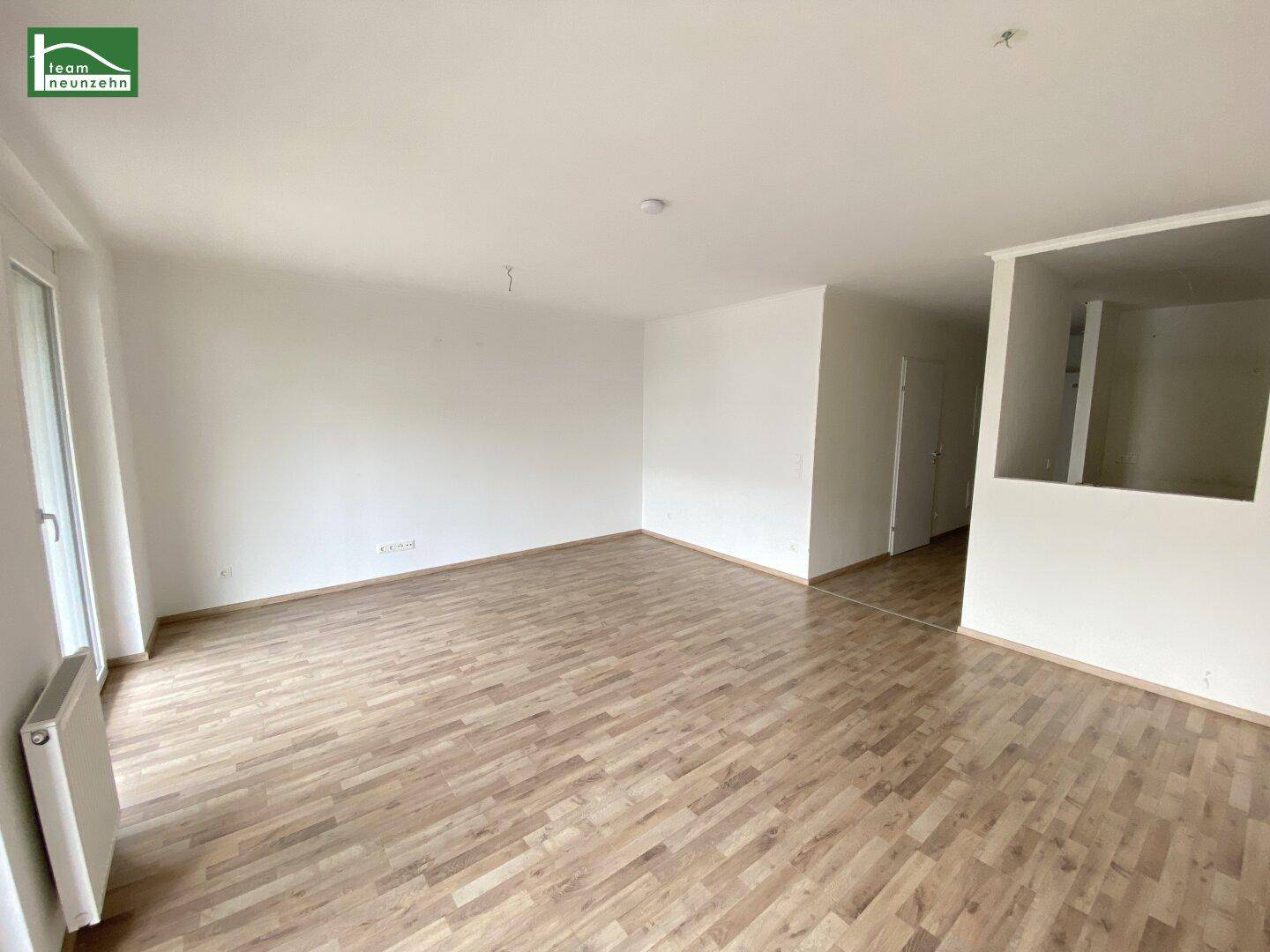 Geräumiger, heller Innenraum mit Laminatboden und weiß gestrichenen Wänden.