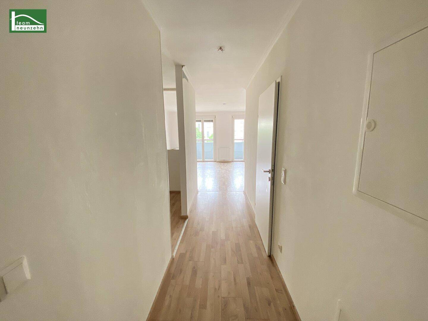 Heller Flur mit Laminatboden, der zu den Wohnbereichen führt.