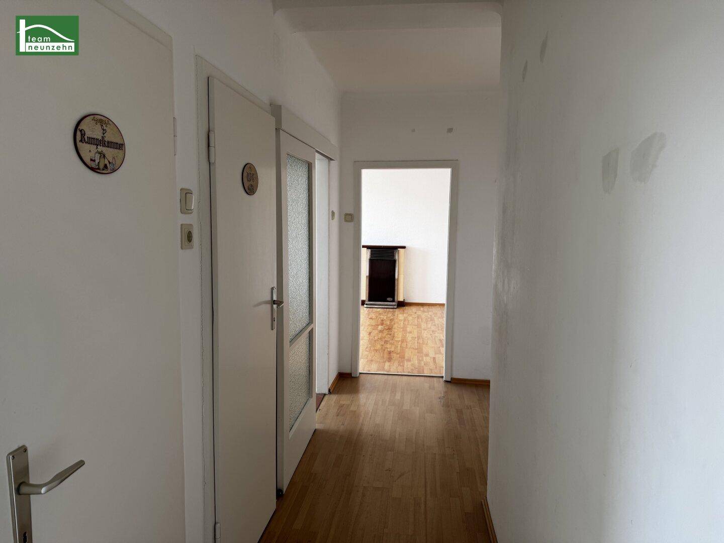 Heller Flur mit Holzboden und Zugang zu weiteren Räumen der Wohnung.