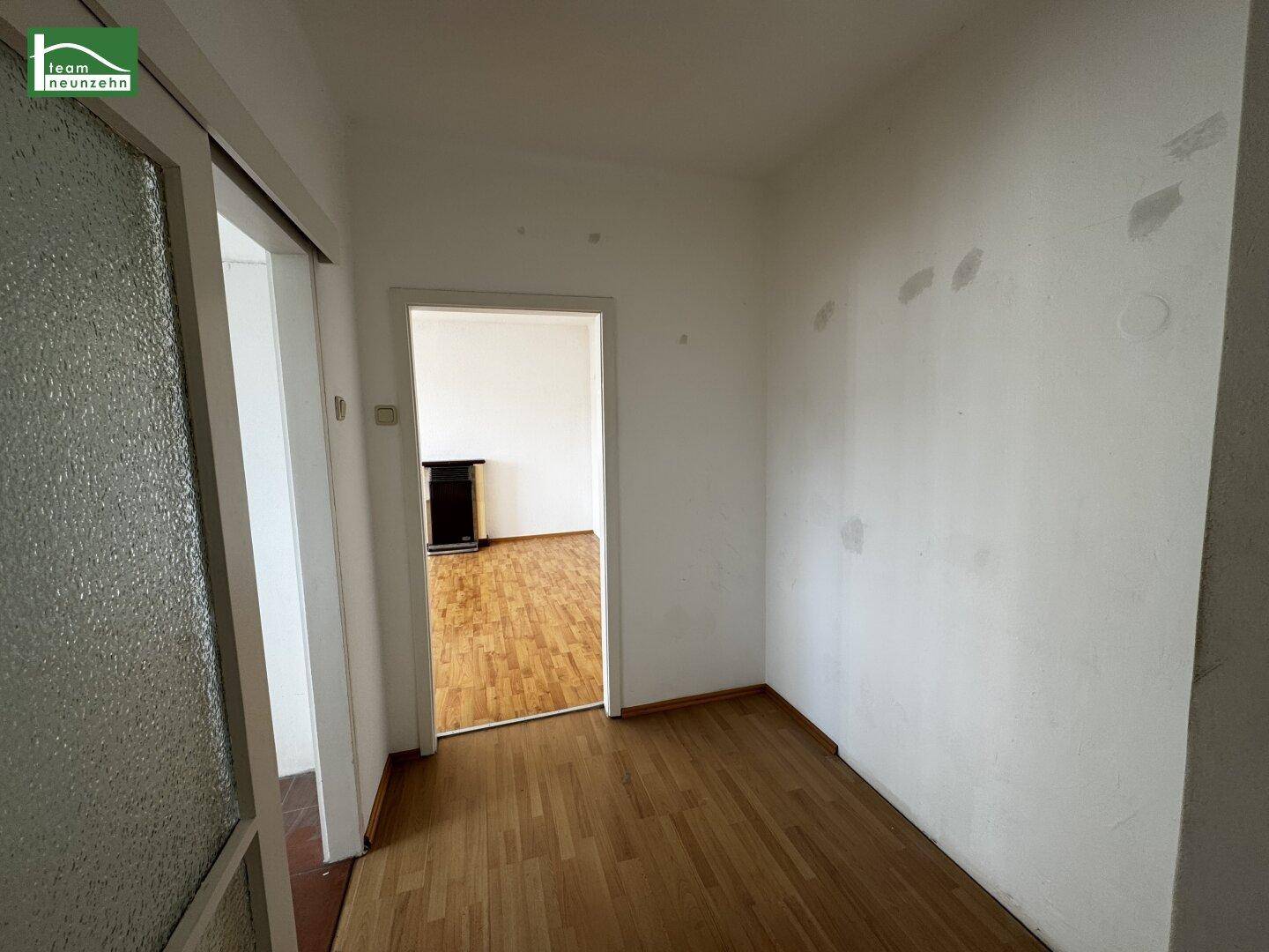 Heller Flur mit Parkettboden und Zugang zu weiteren Räumen der Wohnung.