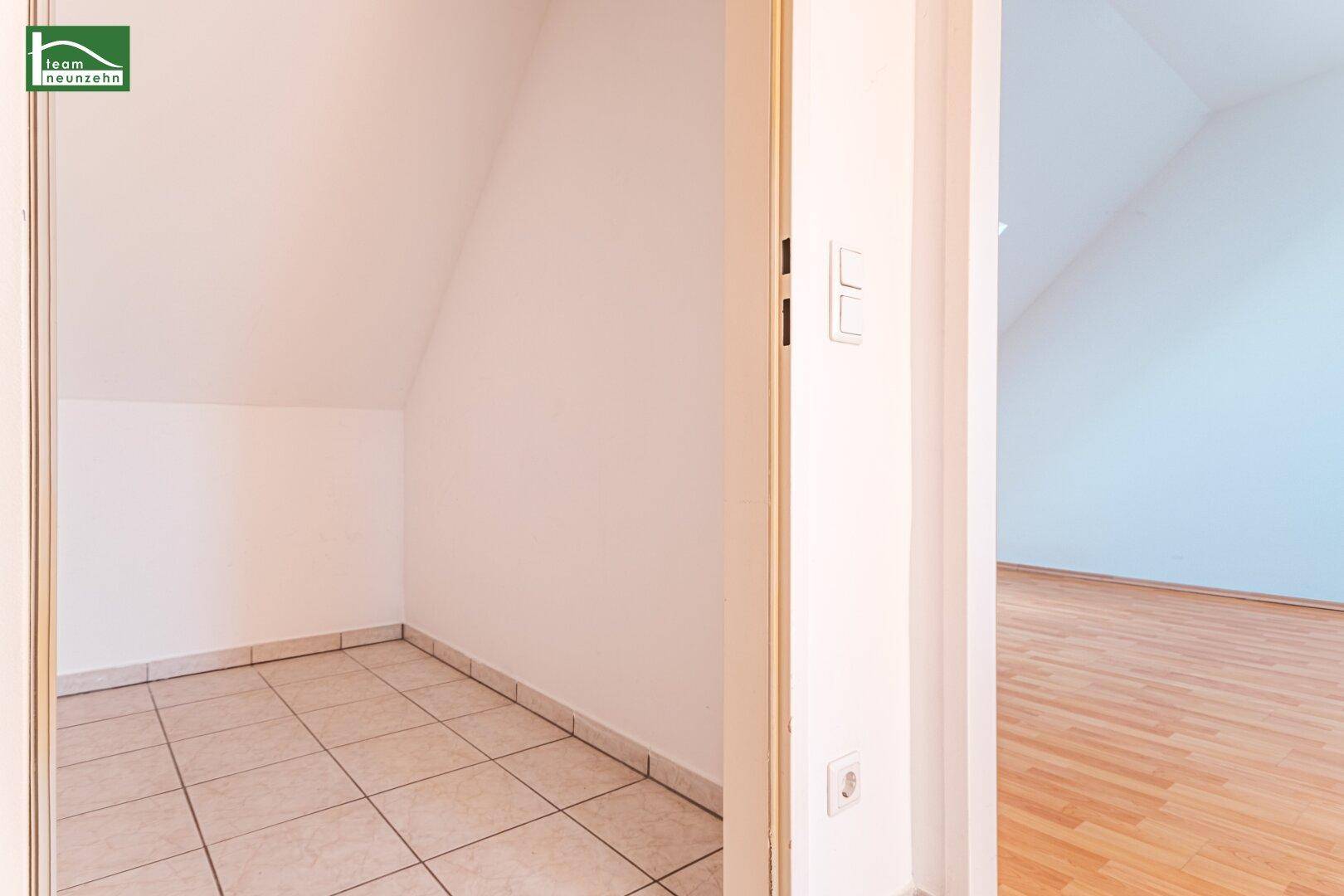 Kleiner Abstellraum mit Fliesenboden und Dachschräge, bietet zusätzlichen Stauraum.